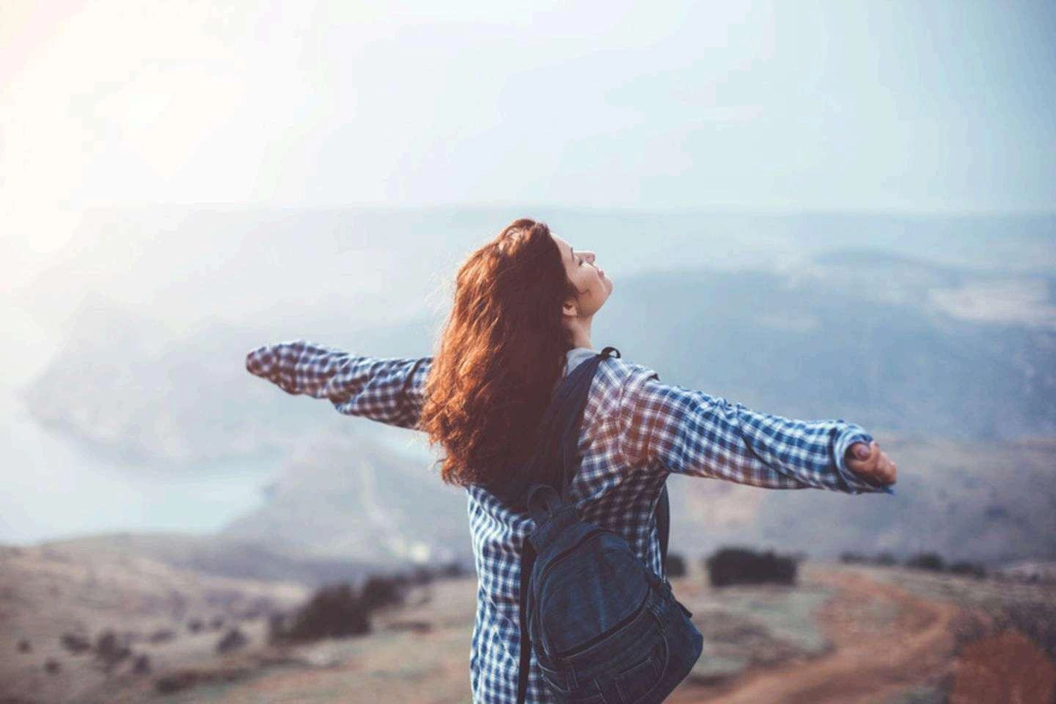 ERHOLUNG DE LUXE - Wandern mit Achtsamkeit Allgäu - Mädchen mit offenen Armen auf dem Gipfel des Berges